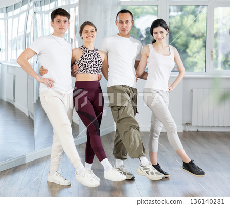 Positive young multinational people forming line while rehearsing traditional Irish stepdance in dance studio Positive young multinational people forming line while rehearsing traditional Irish stepdance in dance studio 136140281