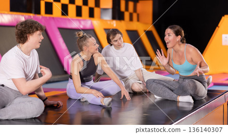 Two women and two teenager boys talking in trampoline center Two women and two teenager boys talking in trampoline center 136140307