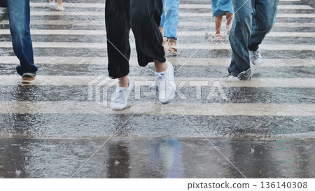 People walking on zebra crossing during rainy day, splashing water from puddles People walking on zebra crossing during rainy day, splashing water from puddles 136140308