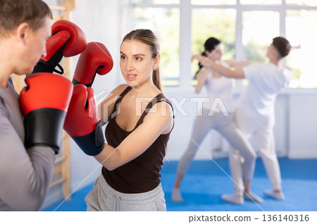 Young woman training in boxing fight in studio 136140316