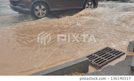 Car driving through flooded street, splashing muddy water during heavy rain 136140317