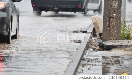 Cars driving through deep puddles on a flooded street during heavy rain Cars driving through deep puddles on a flooded street during heavy rain 136140324