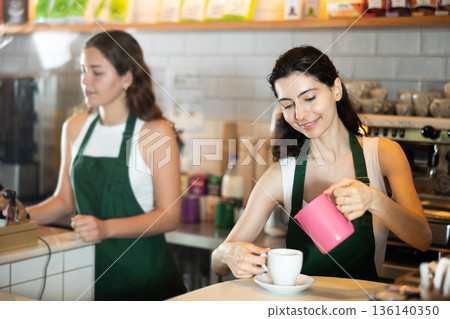 Young woman pouring coffee in cafe Young woman pouring coffee in cafe 136140350