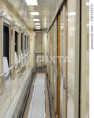 Long hallway inside a sleeper train with windows and doors to passenger cabins Long hallway inside a sleeper train with windows and doors to passenger cabins 136140351