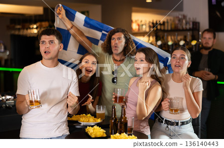 Group of friends cheer together for their favorite Greek team in beer bar Group of friends cheer together for their favorite Greek team in beer bar 136140443