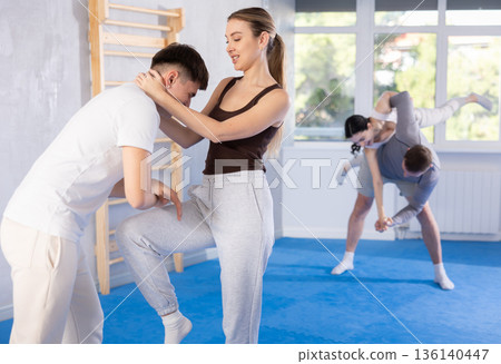 Woman practices blows to the head of a male attacker during self defense training Woman practices blows to the head of a male attacker during self defense training 136140447