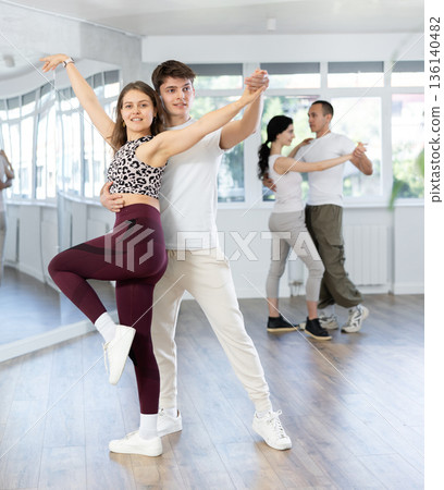 Young men and women dancing latin dances 136140482