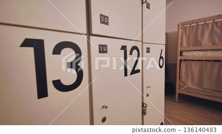 Hostel dormitory with numbered storage lockers and bunk beds for travelers 136140483