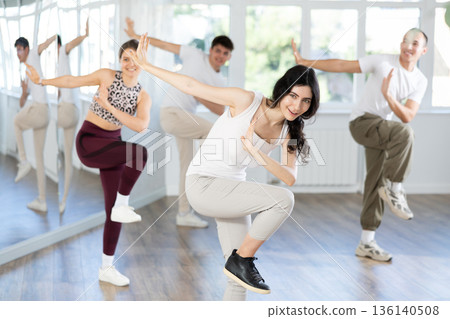 Team of dancers performing contemporary dance in choreography studio 136140508