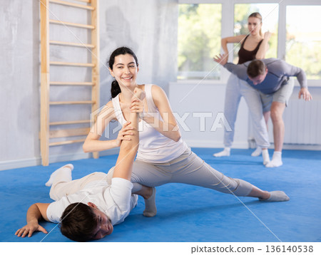 Young woman and guy training self-defense techniques Young woman and guy training self-defense techniques 136140538