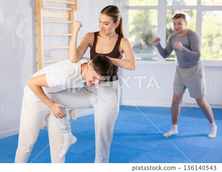 Self defense lesson - woman learns to fight back an attacking man 136140543