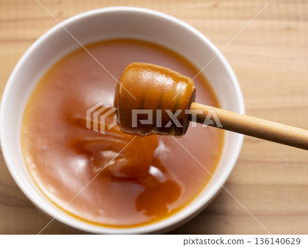 從空中俯瞰，人們正用蜂蜜湯匙舀取濃鬱的麥盧卡蜂蜜（正上方拍攝）。 136140629