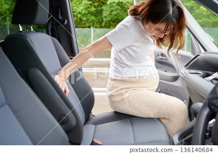 Driving woman, pregnant woman, child 136140684