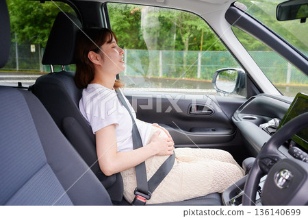 Driving woman, pregnant woman, child Driving woman, pregnant woman, child 136140699