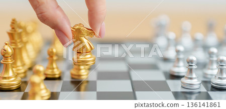 hand moving gold Chess knight figure and Checkmate opponent during chessboard competition. Strategy, Success, management, business planning, win, disruption, Trade war and leadership concept hand moving gold Chess knight figure and Checkmate opponent during chessboard competition. Strategy, Success, management, business planning, win, disruption, Trade war and leadership concept 136141861