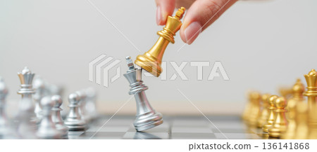 hand moving gold Chess King figure and Checkmate opponent during chessboard competition. Strategy, Success, management, business planning, win, disruption, Trade war and leadership concept hand moving gold Chess King figure and Checkmate opponent during chessboard competition. Strategy, Success, management, business planning, win, disruption, Trade war and leadership concept 136141868