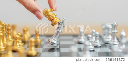 hand moving gold Chess King figure and Checkmate opponent during chessboard competition. Strategy, Success, management, business planning, win, disruption, Trade war and leadership concept hand moving gold Chess King figure and Checkmate opponent during chessboard competition. Strategy, Success, management, business planning, win, disruption, Trade war and leadership concept 136141872