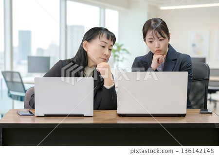 兩位女商人正在用電腦思考 136142148