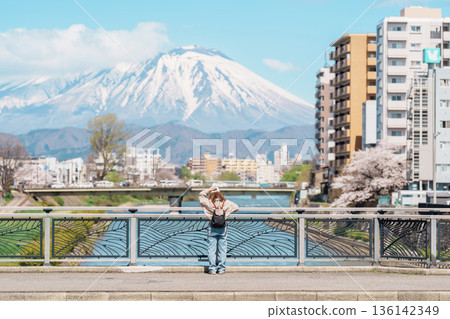 Woman tourist sightseeing Iwate mountain and Kitakami river with flowers in Spring, happy traveler travel in Morioka city, Iwate prefecture, Japan. famous Landmark Travel and Vacation destination 136142349