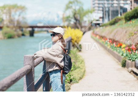 Woman tourist sightseeing Iwate mountain and Kitakami river with flowers in Spring, happy traveler travel in Morioka city, Iwate prefecture, Japan. famous Landmark Travel and Vacation destination Woman tourist sightseeing Iwate mountain and Kitakami river with flowers in Spring, happy traveler travel in Morioka city, Iwate prefecture, Japan. famous Landmark Travel and Vacation destination 136142352