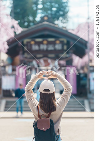 Woman tourist sightseeing Sakurayama Shrine with Cherry blossom in Spring season, happy traveler travel in Morioka city, Iwate prefecture, Japan. famous Landmark Travel and Vacation destination 136142359