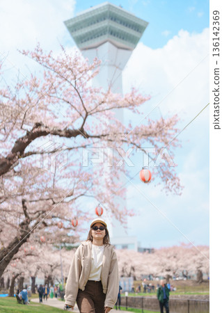 Woman tourist sightseeing Goryokaku Tower park with Sakura Cherry Blossom in Spring, happy traveler travel in Hakodate city, Hokkaido, Japan. famous Landmark, Japan Travel and Vacation destination 136142369