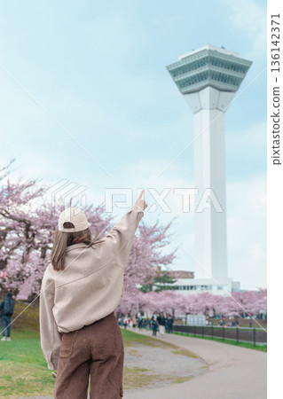Woman tourist sightseeing Goryokaku Tower park with Sakura Cherry Blossom in Spring, happy traveler travel in Hakodate city, Hokkaido, Japan. famous Landmark, Japan Travel and Vacation destination 136142371