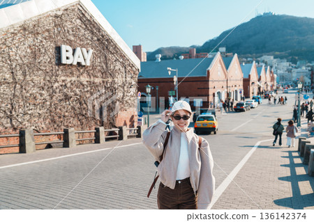 Woman tourist Visiting in Hakodate, happy Traveler sightseeing Kanemori Red Brick Warehouse in spring season. landmark and popular for attractions in Hokkaido, Japan. Travel and Vacation concept Woman tourist Visiting in Hakodate, happy Traveler sightseeing Kanemori Red Brick Warehouse in spring season. landmark and popular for attractions in Hokkaido, Japan. Travel and Vacation concept 136142374