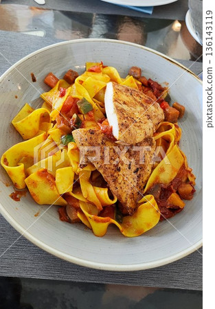 Interlaken, Switzerland - March 17 2023: Pappardelle with chicken at Restaurant Crystal Jungfraujoch Interlaken, Switzerland - March 17 2023: Pappardelle with chicken at Restaurant Crystal Jungfraujoch 136143119