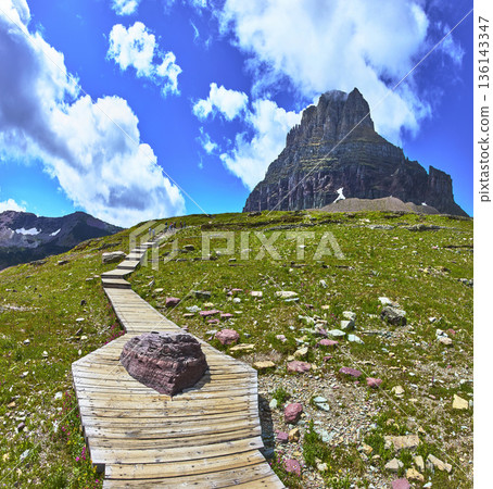 Hidden Lake Trail Boardwalk and Mountain Under Blue Sky in Montana Hidden Lake Trail Boardwalk and Mountain Under Blue Sky in Montana 136143347
