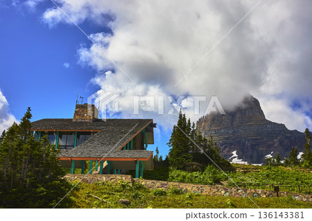 Modern Mountain Lodge and Dramatic Peak with Lush Greenery and Blue Sky 136143381