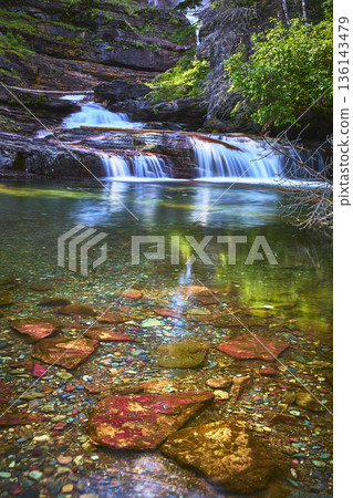 Waterfall and Crystal Clear Pool with Colorful Rocks and Lush Green Foliage Waterfall and Crystal Clear Pool with Colorful Rocks and Lush Green Foliage 136143479