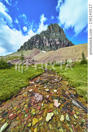 Mountain Stream Colorful Rocks and Dramatic Peak Under Blue Sky 136143517