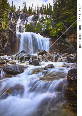 Tangle Falls Waterfall Flowing Over Rocks With Evergreen Trees In Jasper Canada Tangle Falls Waterfall Flowing Over Rocks With Evergreen Trees In Jasper Canada 136143582