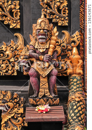 Balinese guardian statue standing at temple entrance with traditional offerings for travel concept Balinese guardian statue standing at temple entrance with traditional offerings for travel concept 136143671