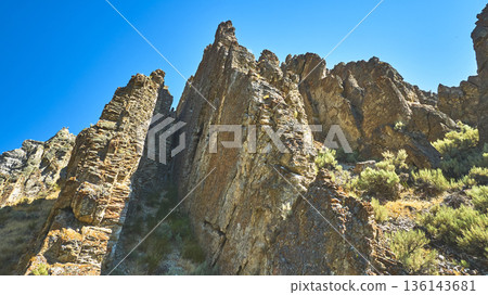 Rocky Formations and Shrubs Under Clear Blue Sky Low Perspective Rocky Formations and Shrubs Under Clear Blue Sky Low Perspective 136143681