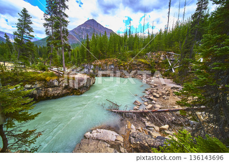 Turquoise River and Rocky Canyon in Lush Forest Near Mountain Peak 136143696