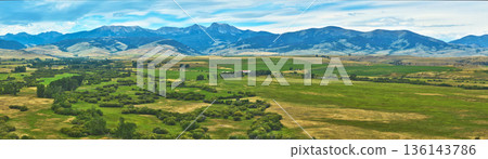 Aerial Wyoming Panorama with Rolling Grasslands and Majestic Mountain Range 136143786