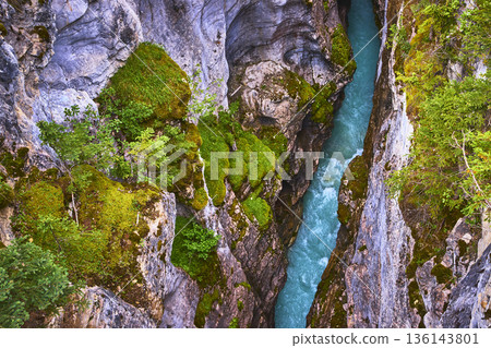 Top Down Mossy Canyon Walls and Turquoise River Flowing Through Rugged Landscape 136143801