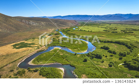 Aerial Meandering River Green Fields and Mountain Landscape Near Cokeville Wyoming 136143824