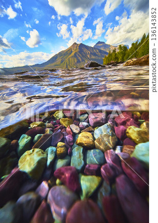 Split Shot Underwater View of Colorful Lake Rocks and Mountain Landscape 136143852