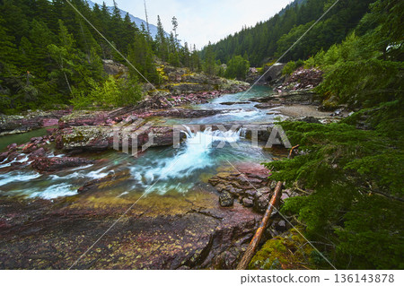 Red Rock River Cascade and Lush Forest Landscape in Glacier National Park Red Rock River Cascade and Lush Forest Landscape in Glacier National Park 136143878