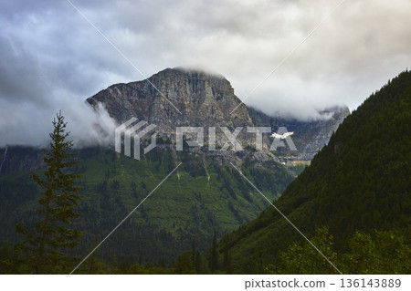 Cloud Shrouded Mountain Peak and Lush Forest in Dramatic Glacier Wilderness Cloud Shrouded Mountain Peak and Lush Forest in Dramatic Glacier Wilderness 136143889