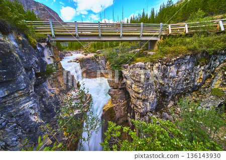 Waterfall Rushing Through Marble Canyon Under Wooden Bridge and Lush Forest 136143930