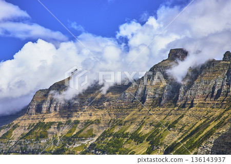 Majestic Rocky Mountain Ridge with Dramatic Clouds and Bright Blue Sky 136143937