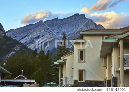 Modern Building and Lush Trees in Town of Banff with Majestic Mountain Backdrop 136143991