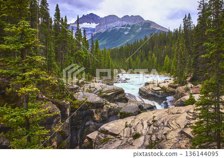 Mistaya Canyon River Flowing Through Evergreen Forests and Mountains Mistaya Canyon River Flowing Through Evergreen Forests and Mountains 136144095