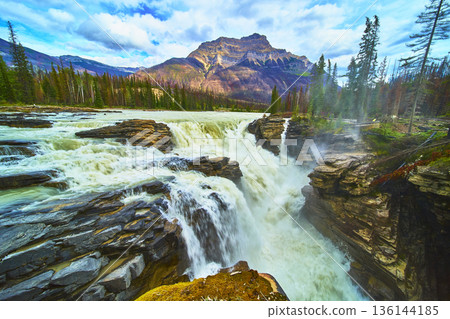 Athabasca Falls Waterfall Flowing Over Rocky Cliffs With Mountain In Background Athabasca Falls Waterfall Flowing Over Rocky Cliffs With Mountain In Background 136144185