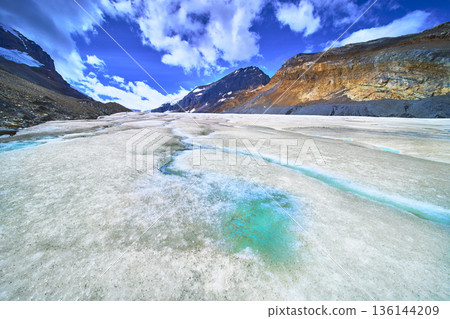 Athabasca Glacier Meltwater Stream and Mountain Landscape Under Blue Sky Athabasca Glacier Meltwater Stream and Mountain Landscape Under Blue Sky 136144209