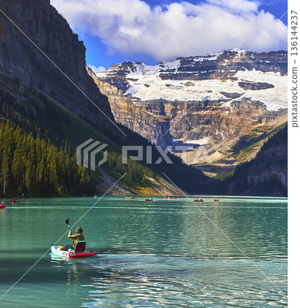 Kayak on Turquoise Lake with Canoes and Snow Capped Mountain in Summer Banff Canada 136144237